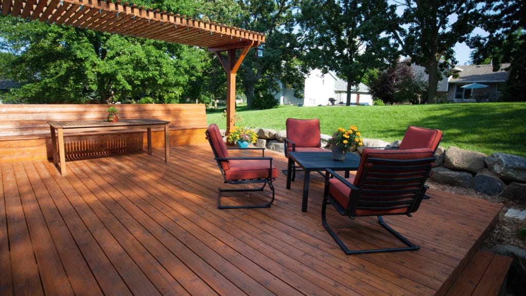 Timber deck with a covered pergola seating area and outdoor furniture
