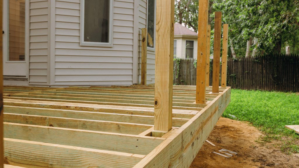 Close-up of a nail gun fastening timber floor joists during construction
