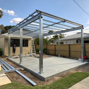 Steel pergola frame under construction in a suburban Ipswich backyard